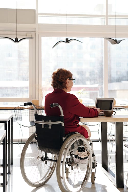Woman in Red Long Sleeves Sitting on Wheelchair