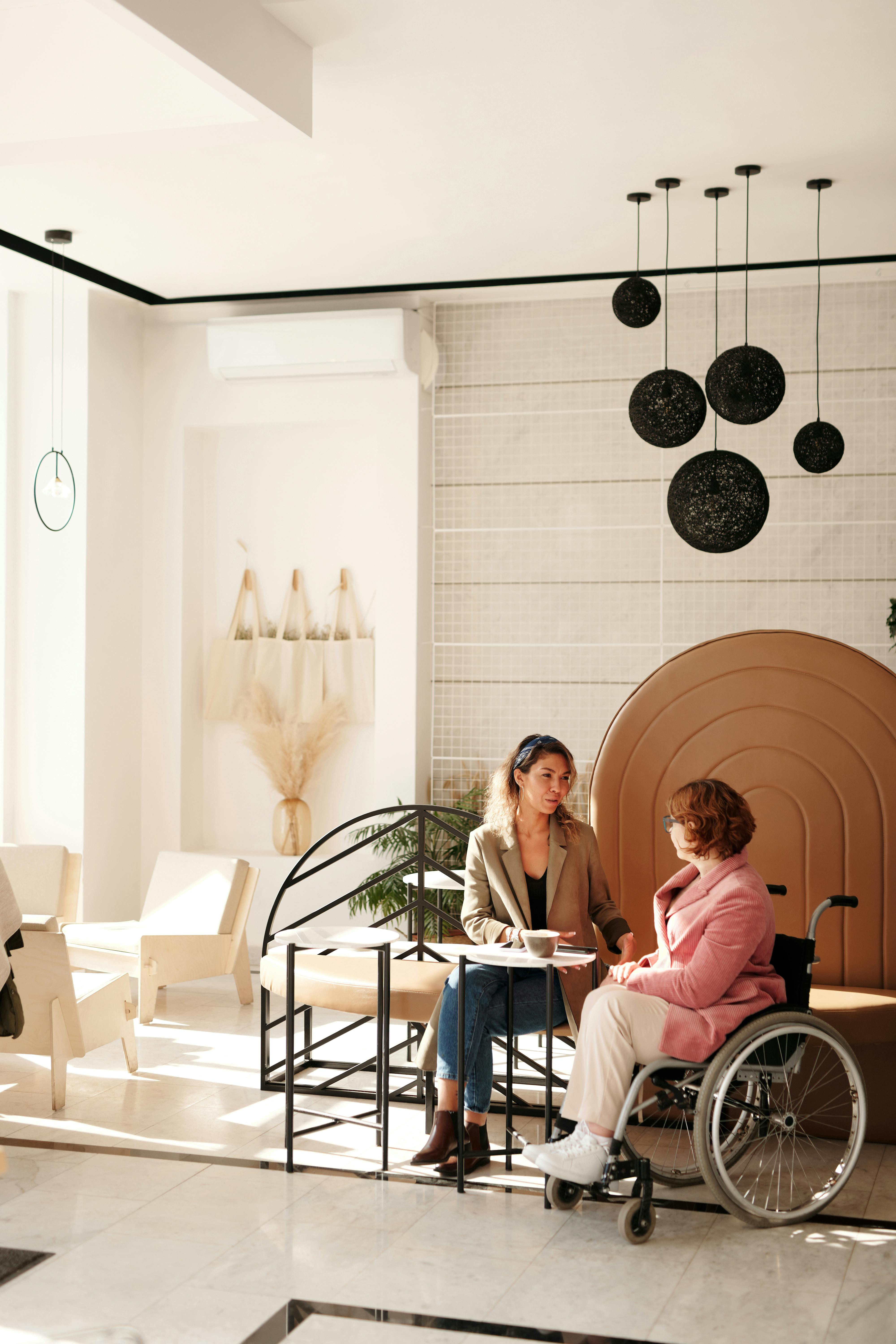 Free A business meeting between two women, one in a wheelchair, in a stylish modern room. Stock Photo