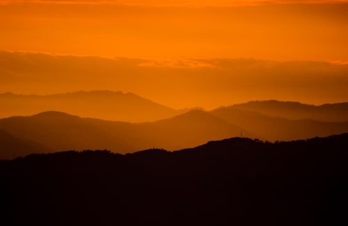 Free A breathtaking silhouette of mountains under a vibrant sunset sky, perfect for nature lovers. Stock Photo