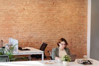 女商人坐在时尚的办公室里，用笔记本电脑进行远程工作