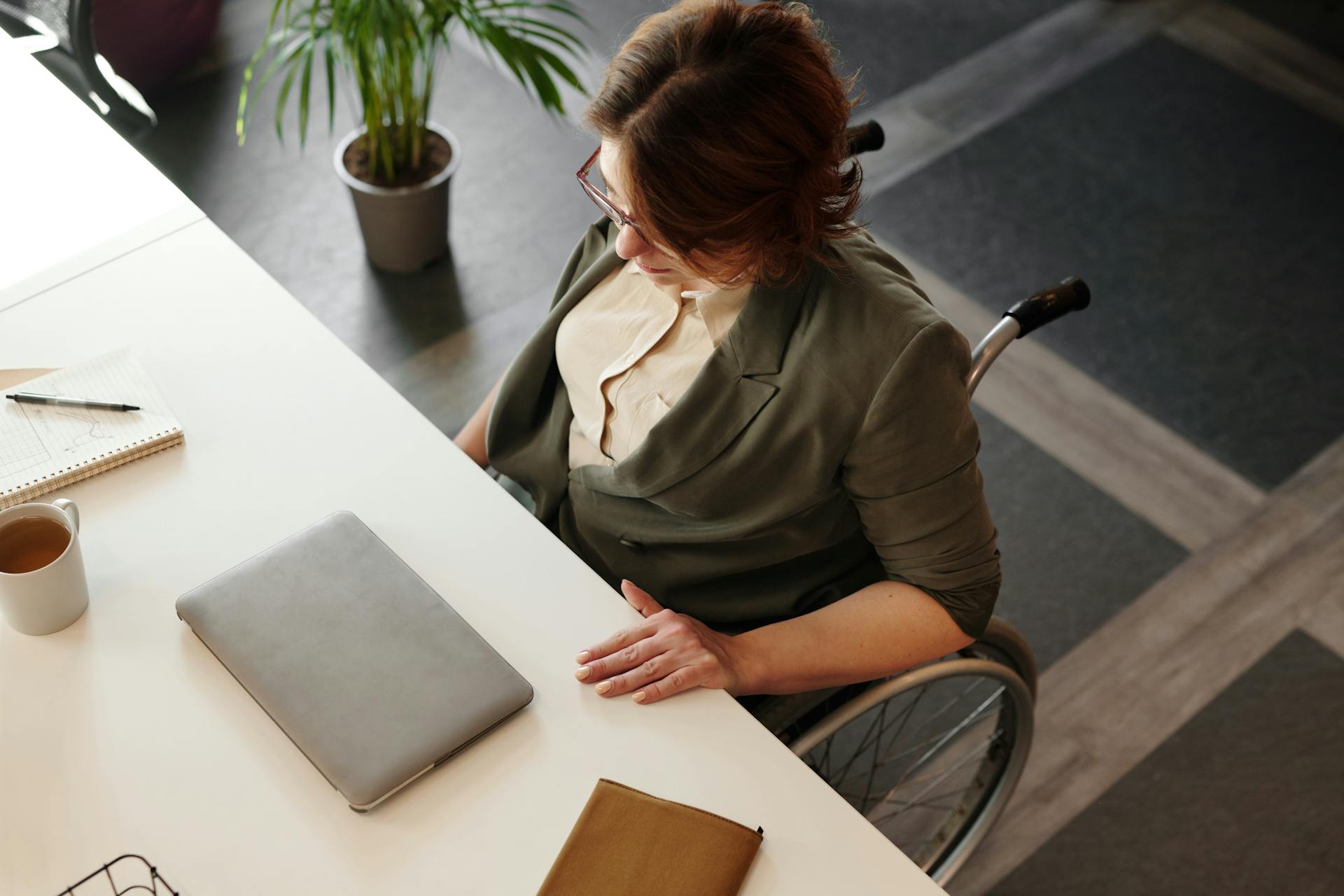 High Angle Photo of Woman Sitting on Wheelchair by the Table