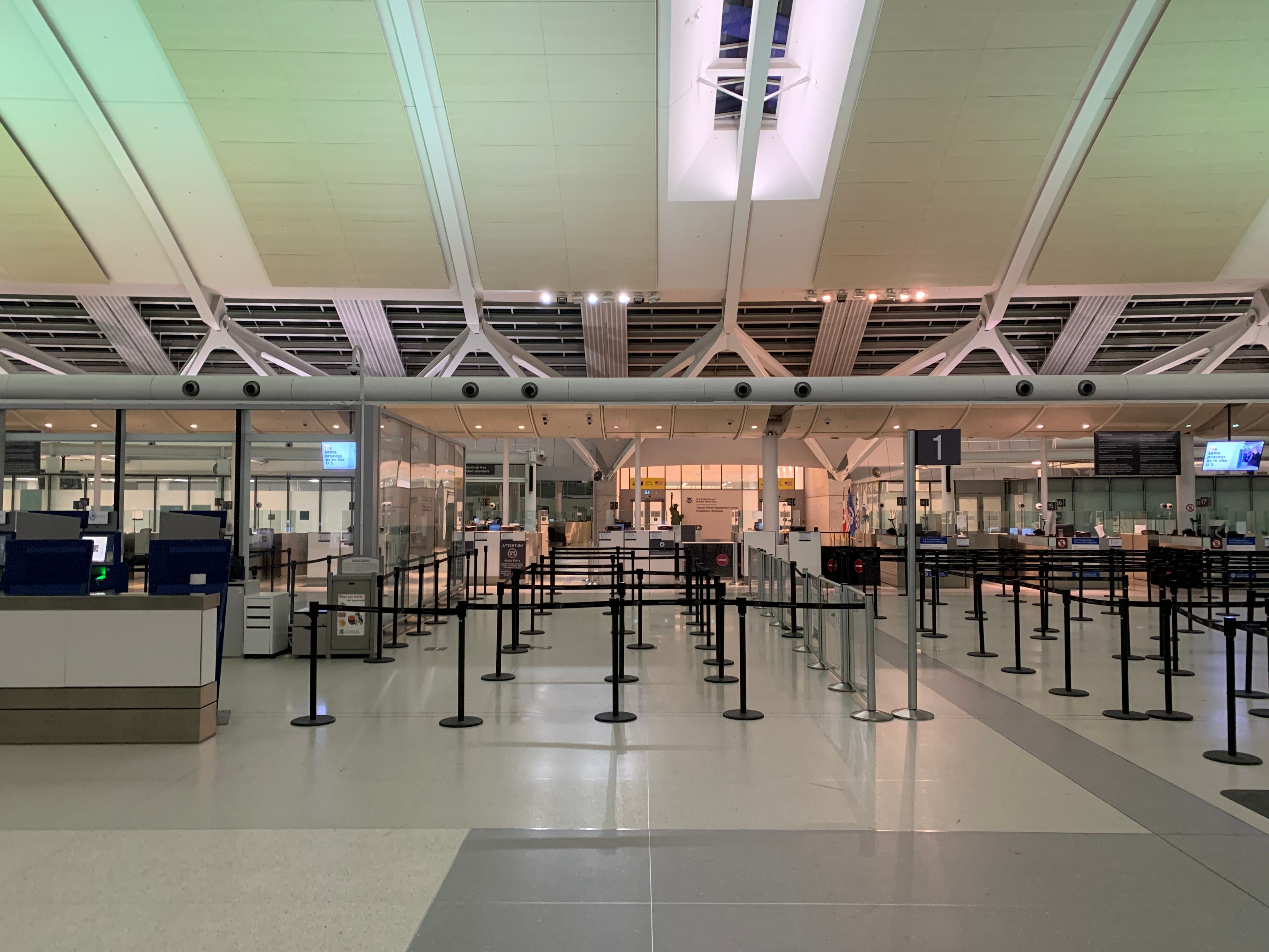 Empty airport security checkpoint with queue barriers and screening counters