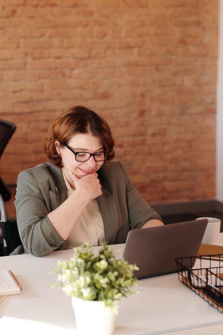 Photo Of Woman Smiling While Using Laptop