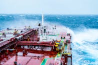 一艘货船在晴朗的日子里航行于汹涌的海浪中