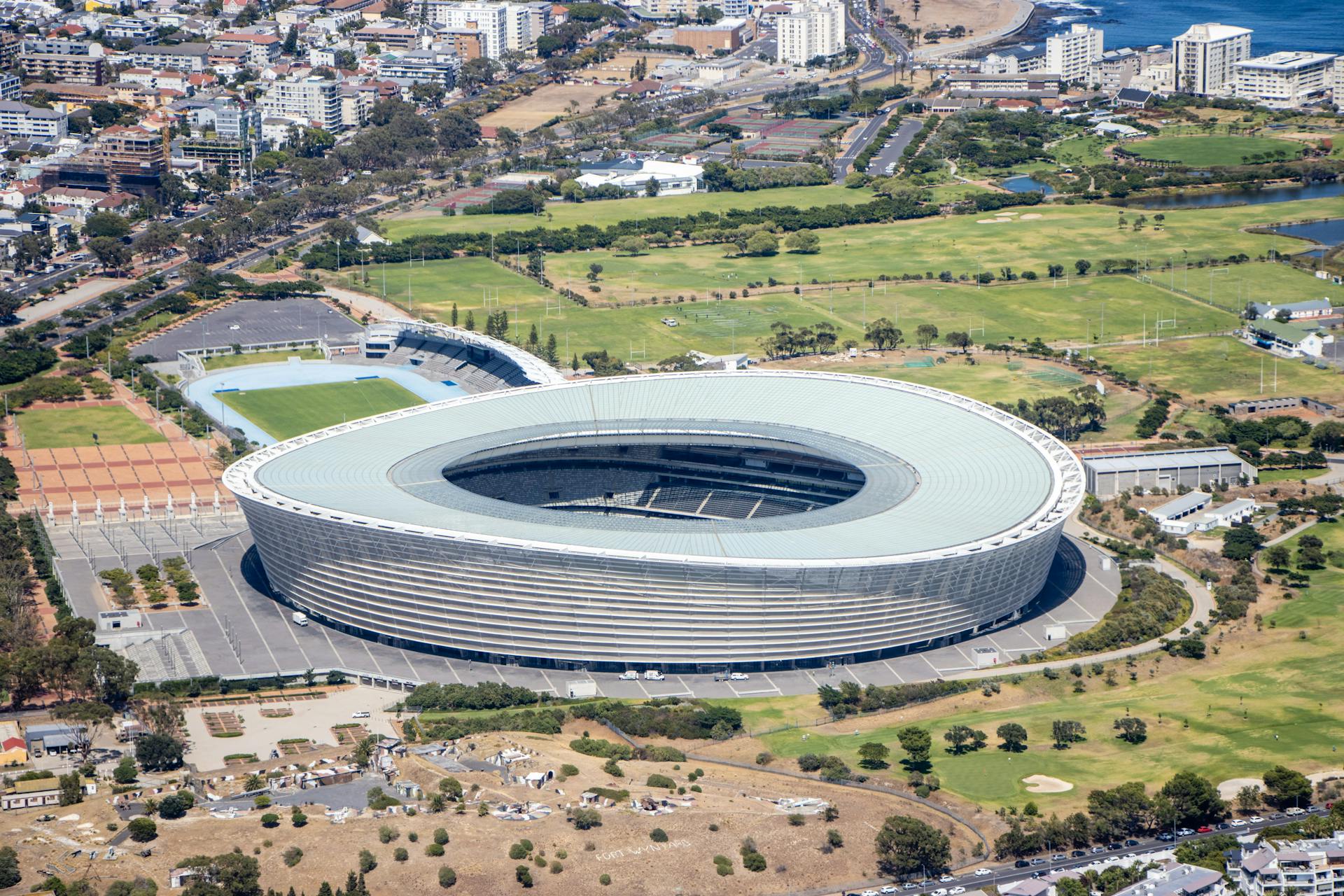 A stunning aerial shot showcasing the iconic Cape Town Stadium surrounded by the urban landscape and greenery.
