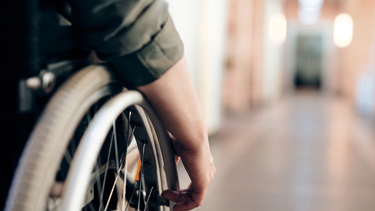 Traveler in a wheelchair moving down an interior hallway