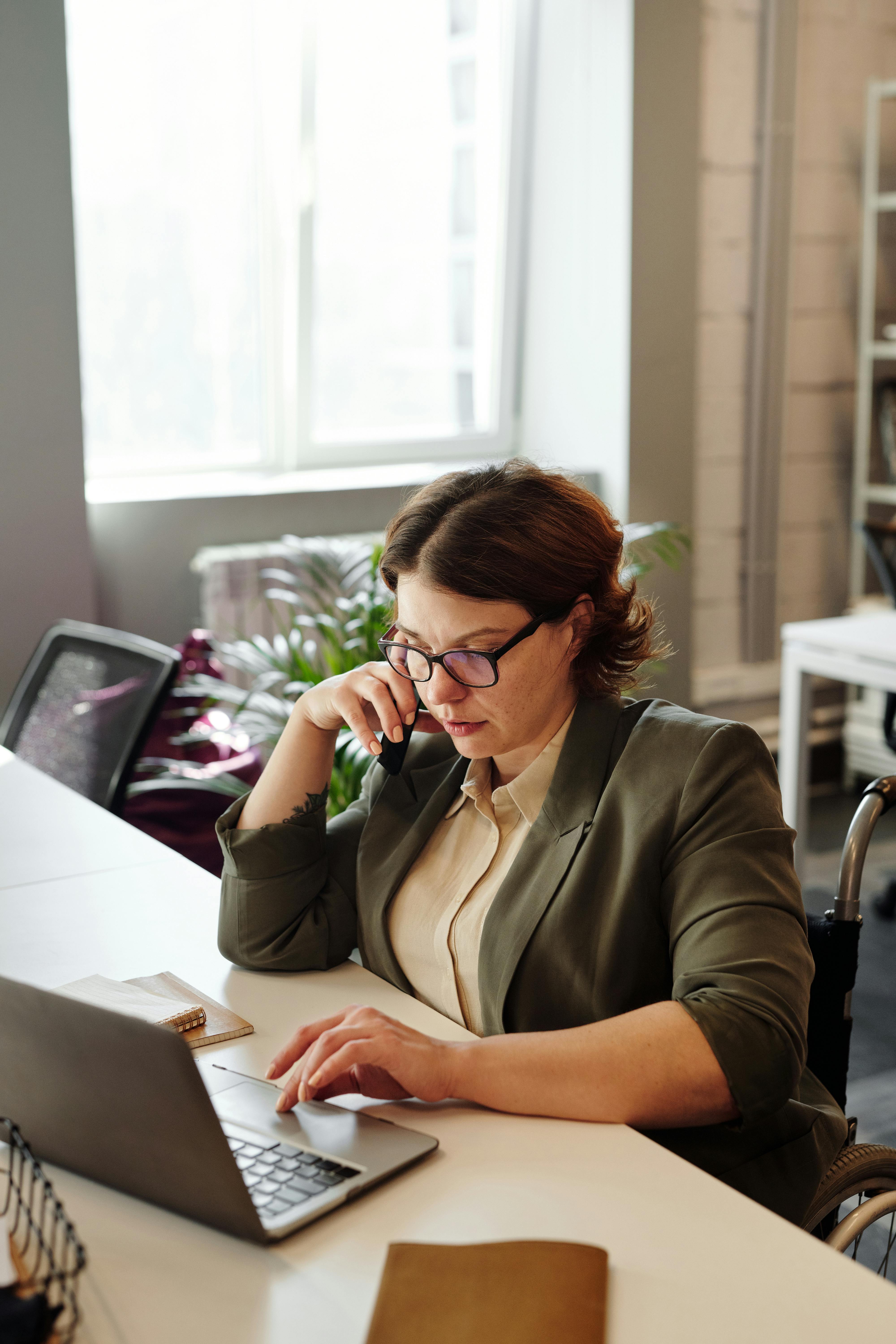 woman using smartphone and laptop