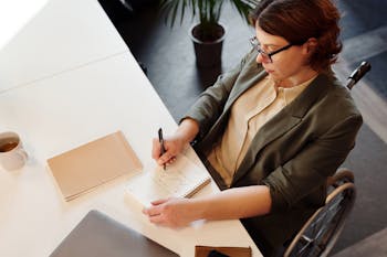 High Angle Photo of Woman Writing on Notebook