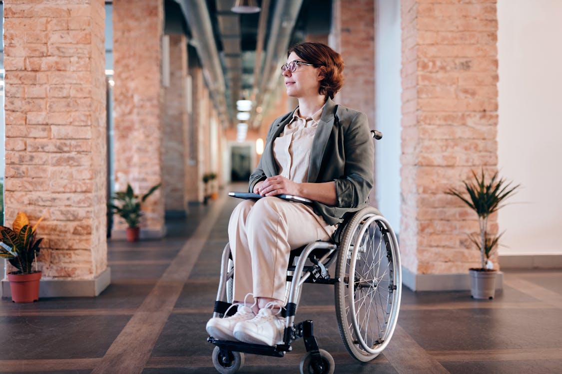Free Woman in Gray Coat Sitting on Wheelchair Stock Photo