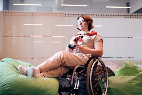 Free Woman Sitting on Black Wheelchair While Holding Joystick Stock Photo
