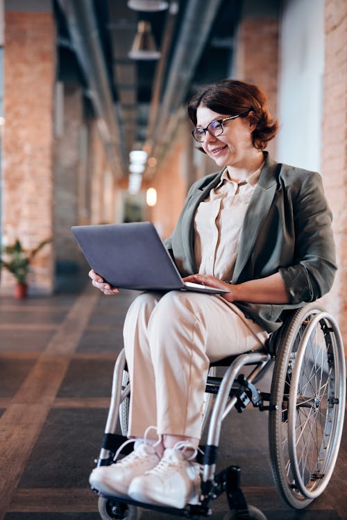 Free Photo of Woman Sitting on Wheelchair While Using Laptop Stock Photo