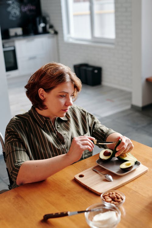 Photo of Woman Slicing an Avocado
