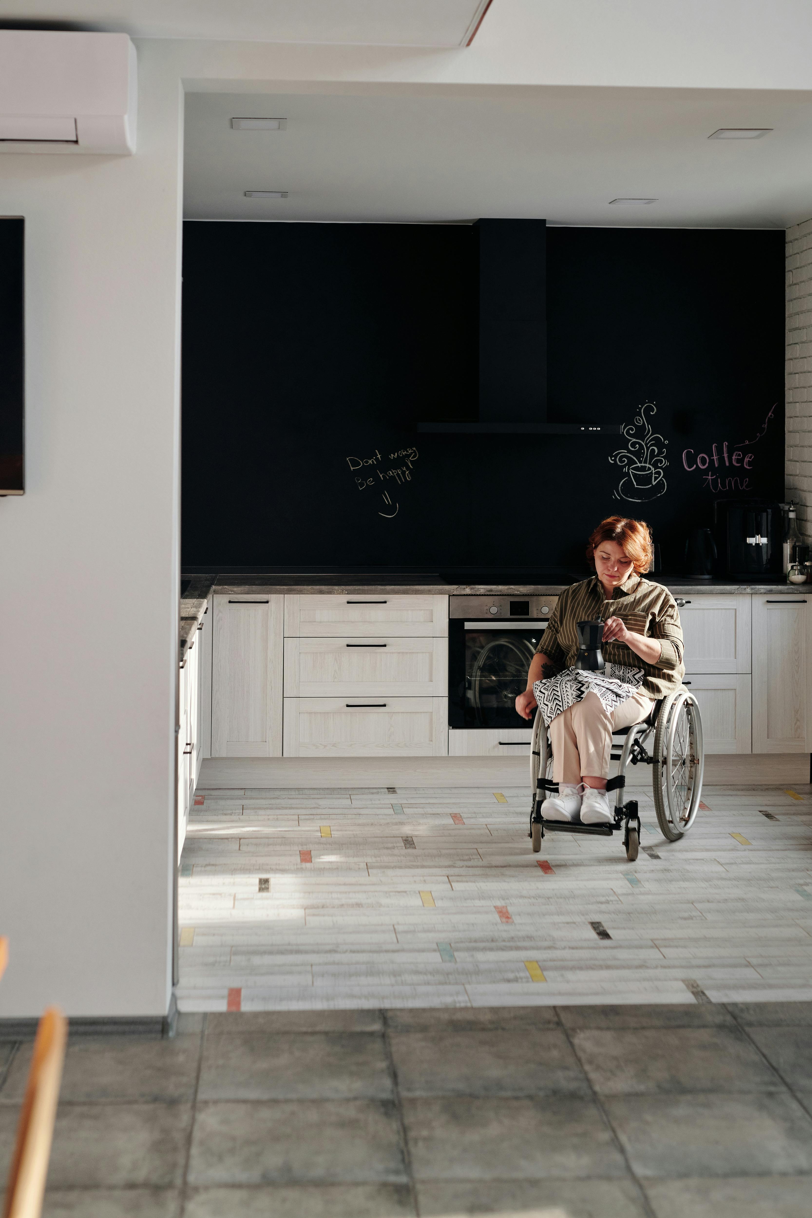 一位坐在轮椅上的女人在舒适的厨房里喝着咖啡，享受家中的宁静