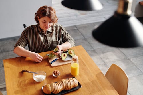 Free High Angle Photo of Woman Holding an Avocado Stock Photo