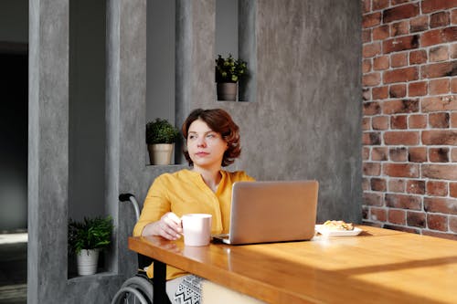 Free Photo of Woman Sitting by the Table While Looking Away Stock Photo
