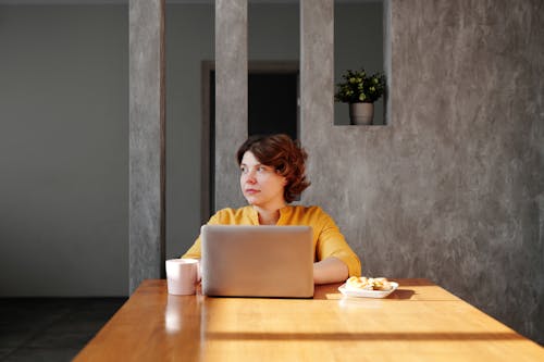 Free Photo of Woman Sitting by the Table While Looking Away Stock Photo