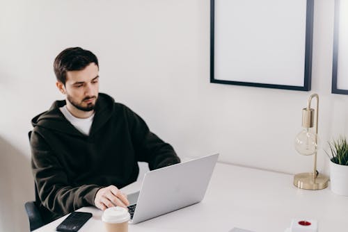 Man in Black Sweater Sitting at Table