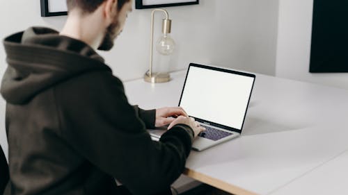 Man in Black Jacket Using Macbook Pro