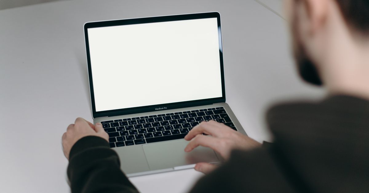 A Person Using Computer Mac Person Using Macbook Air on White Table · Free Stock Photo