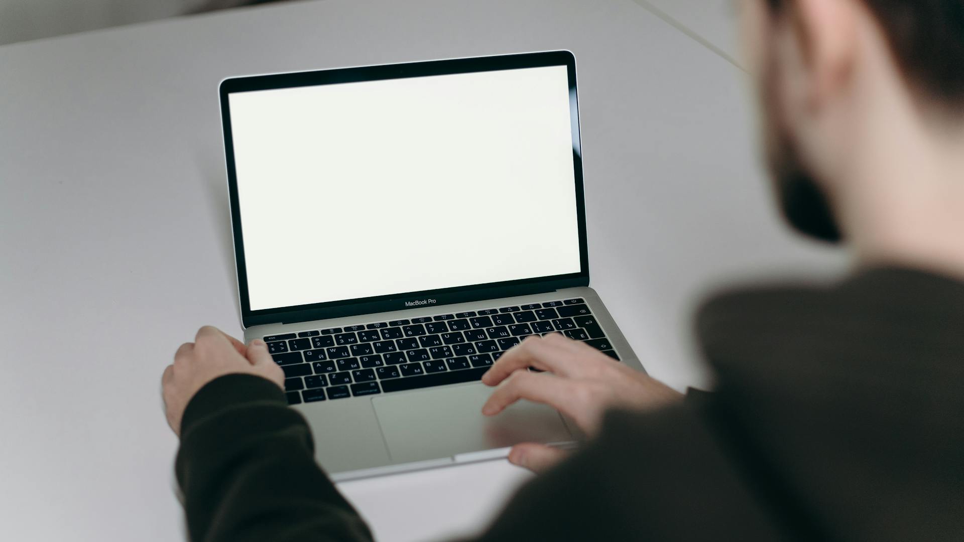 Person Using Macbook Air on White Table