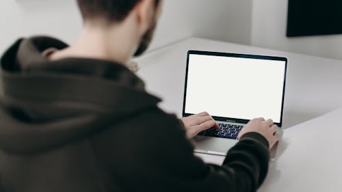 Man in Black Jacket Using Macbook Pro