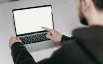 成人在家庭办公室中设置并使用空白屏幕笔记本电脑，同时指向屏幕