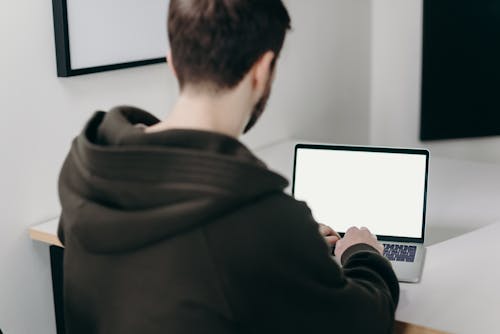 Man in Black Hoodie Using Macbook Pro