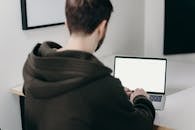 Man in Black Hoodie Using Macbook Pro