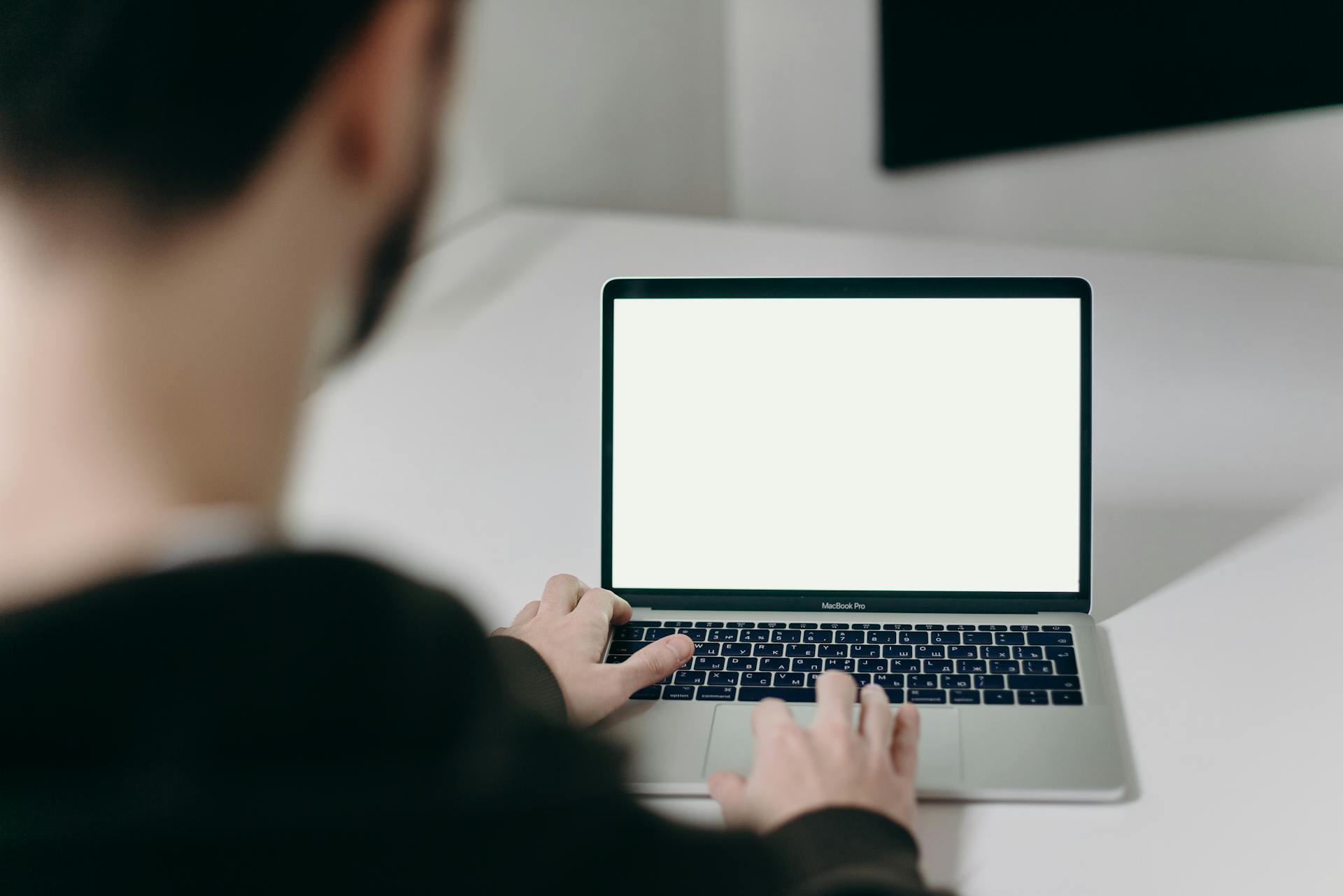 Person Using Macbook Pro on White Table