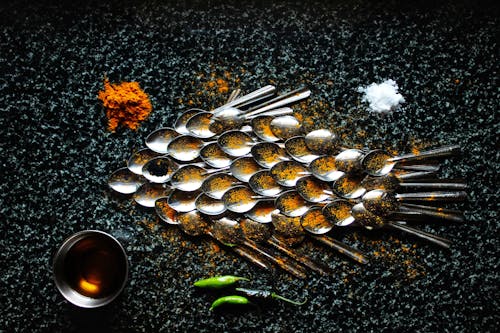 Steel spoons and spices in creative serving