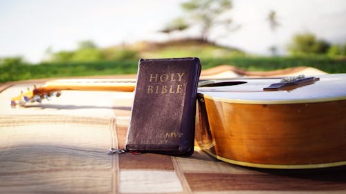 Free Photo of Holy Bible Near Acoustic Guitar Stock Photo