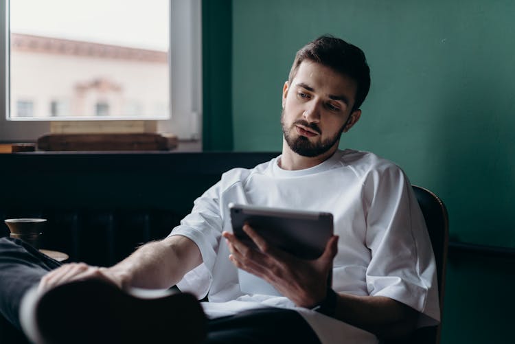 Man In White Shirt Holding An Ipad