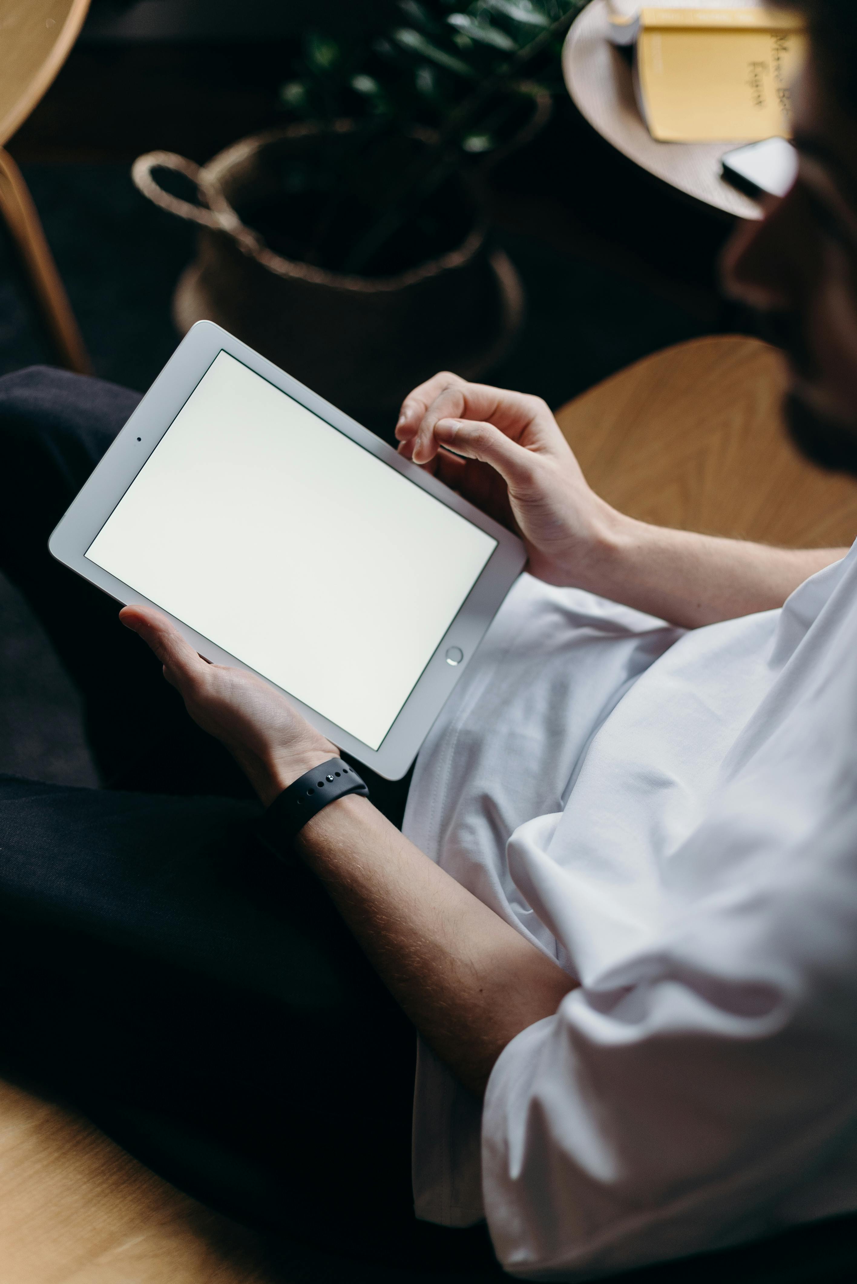 person holding white tablet computer