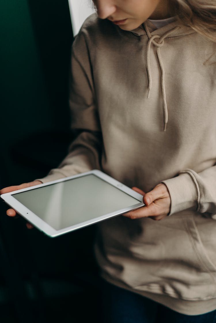 Person In Gray Long Sleeve Shirt Holding White Ipad