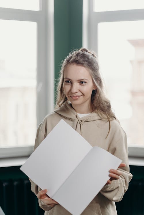 Woman in Brown Coat Holding White Paper