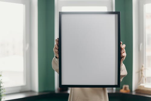 Person Holding White and Black Frame
