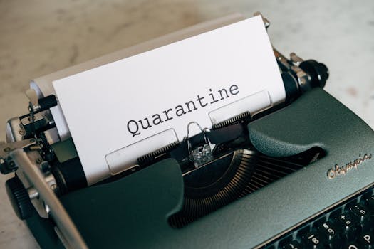 Close-up of a vintage typewriter with 'Quarantine' printed on paper.