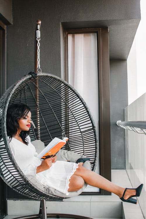 Woman in White Shirt Sitting on Black Hammock