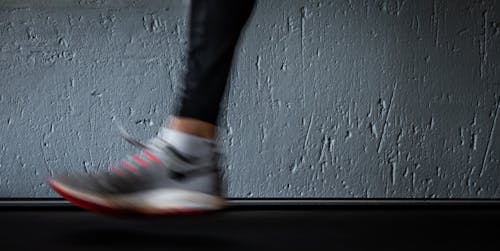 Person in Black Pants Wearing White and Red Nike Sneakers