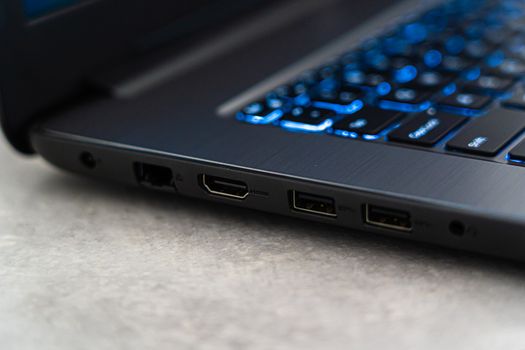 Detailed close-up of a laptop featuring backlit keyboard and various ports highlighting modern technology.