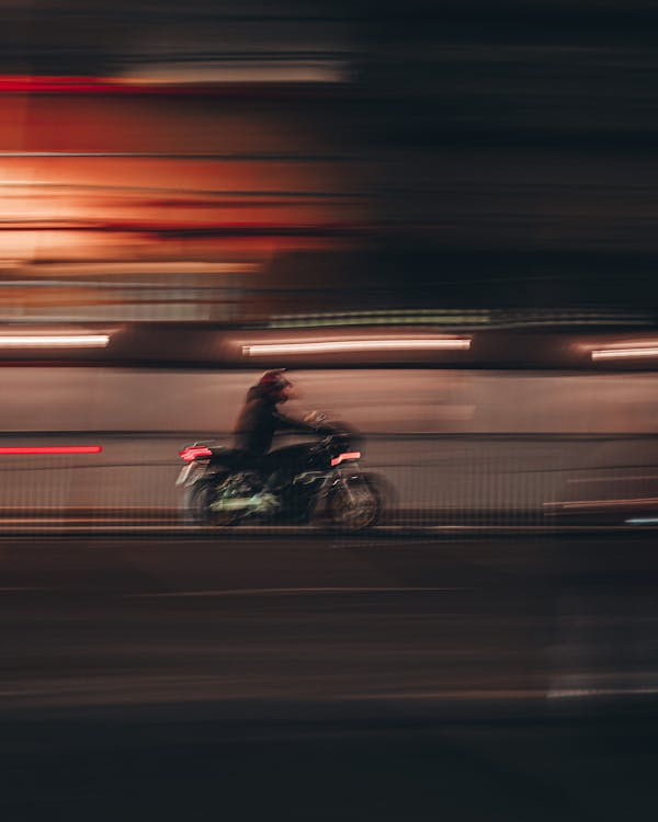 Человек на мотоцикле на дороге в ночное время