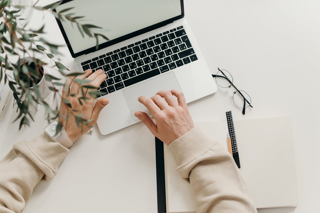 Free Person in Beige Long Sleeve Shirt Using Macbook Pro Stock Photo