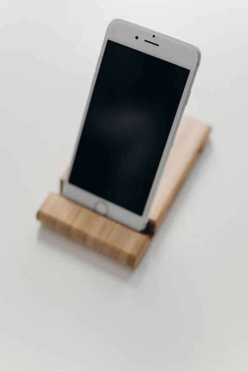 White Ipad on Brown Wooden Stand