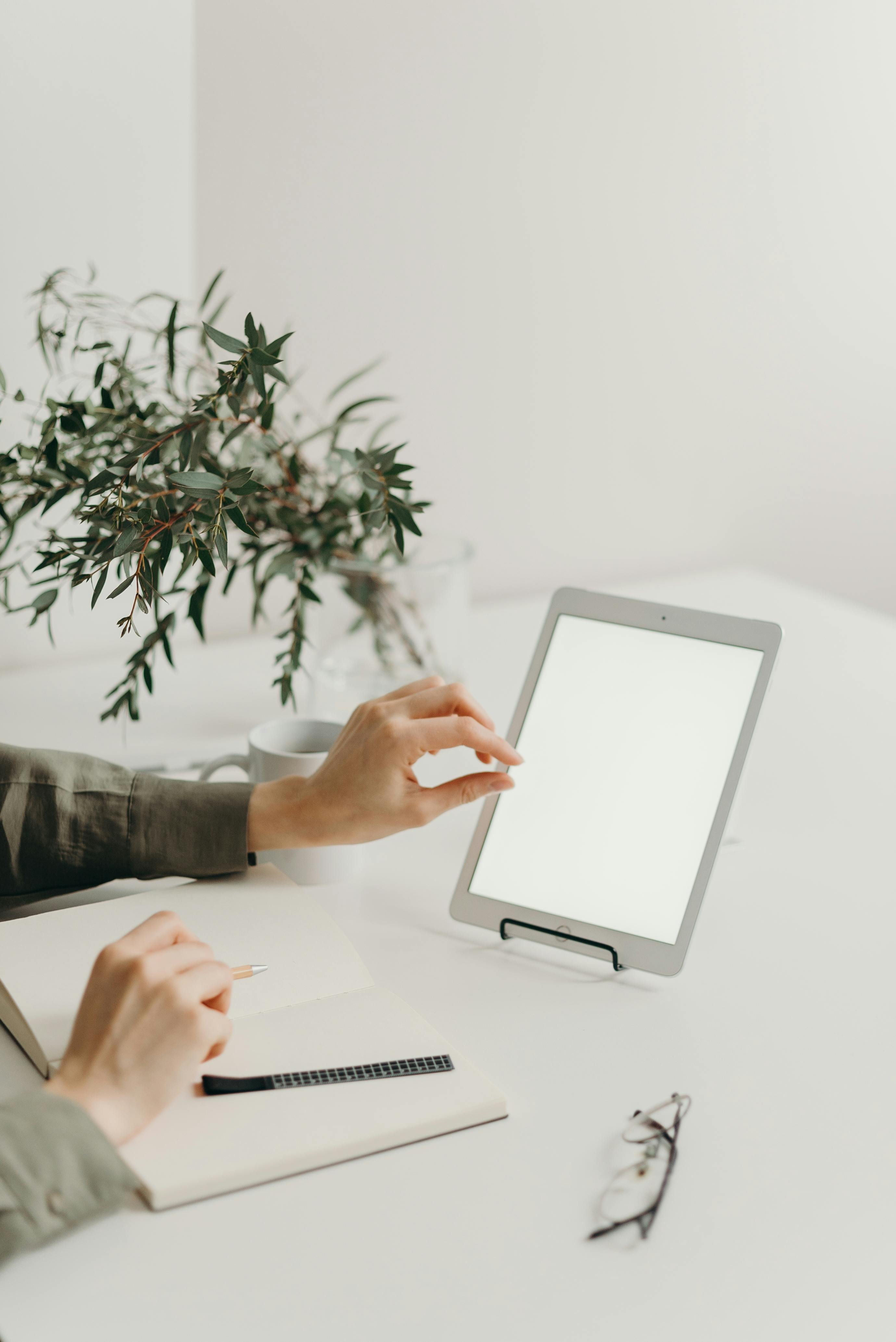 person holding white tablet computer