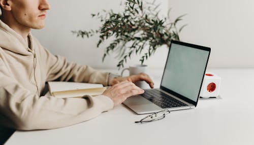 Person in Brown Long Sleeve Shirt Using Black Laptop Computer