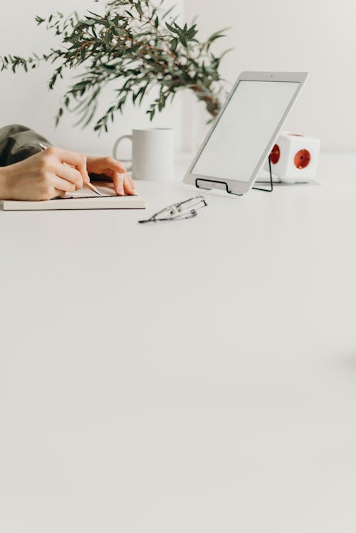 Free Person Using Silver Macbook on White Table Stock Photo