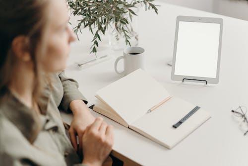 Free Boy in Gray Jacket Sitting Beside Table With White Printer Paper and White Ceramic Mug Stock Photo