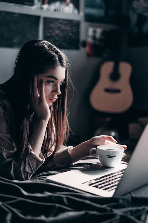 Photo De Femme Allongée Sur Le Lit En Utilisant Un Ordinateur Portable