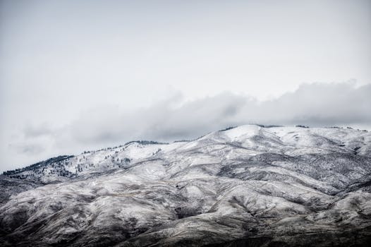 Beautiful snow-covered mountain landscape with cloudy sky, capturing the serene essence of winter.