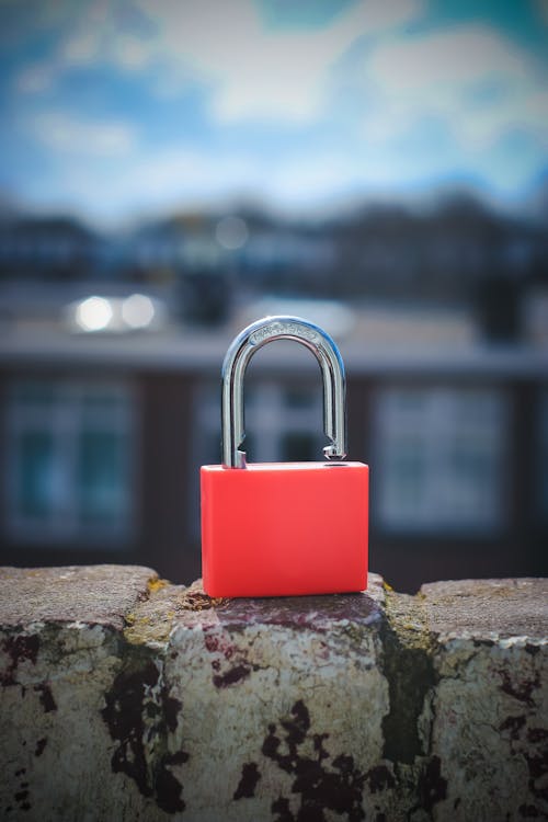 Red Padlock on Brown Rock